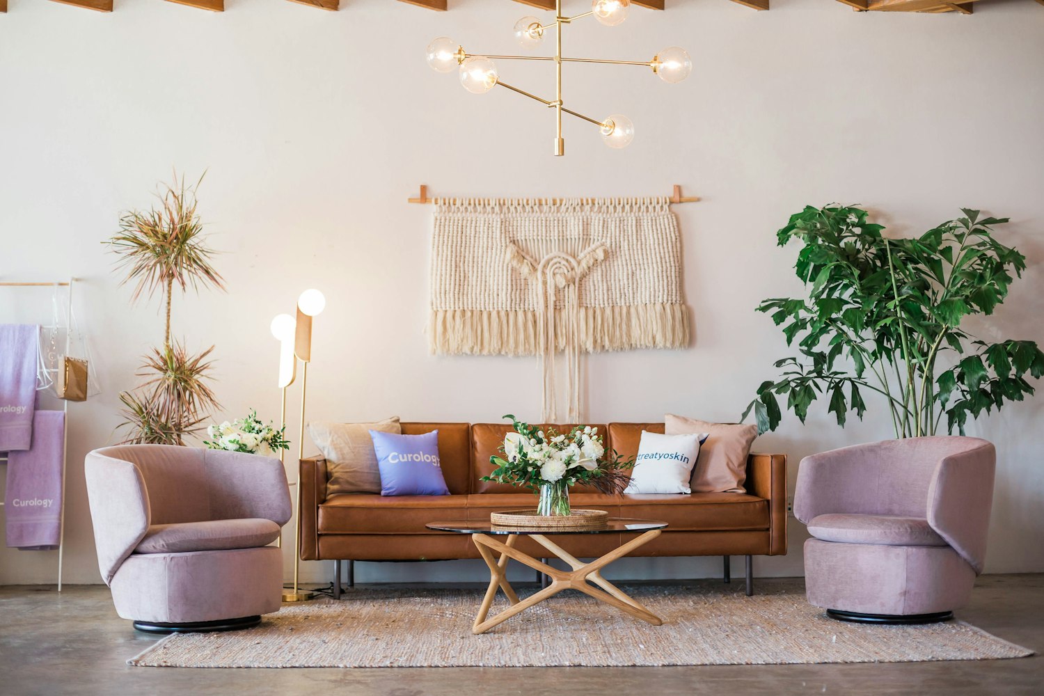 A warm living room with a tan leather sofa, woven textiles and handmade ceramics